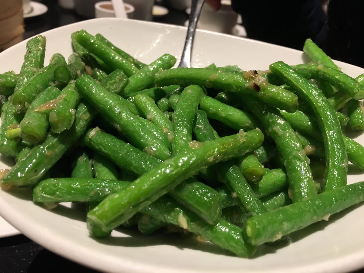 A skillet of sautéed green beans with garlic