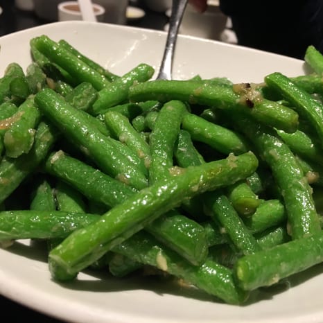 A skillet of sautéed green beans with garlic