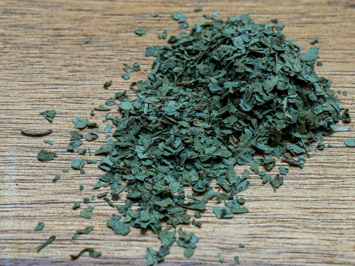 Dried cilantro leaf flakes, pale green and papery