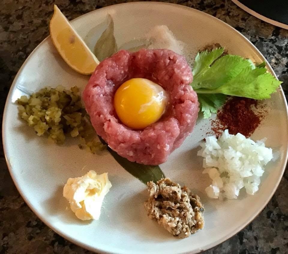 Hand-cut beef tatar with yolk, pickles, capers, onion