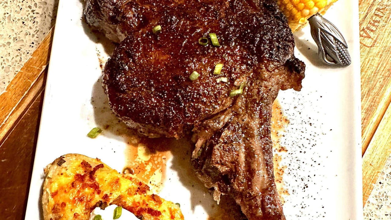 Bone-in ribeye with twice-baked potato and corn, overhead