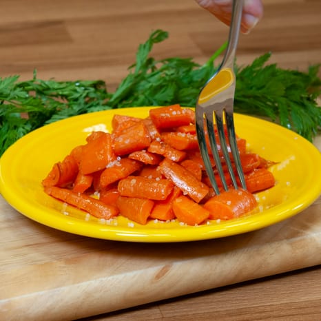 Roasted carrot sticks on a light wooden board
