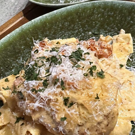 Creamy sun-dried tomato chicken over wide pappardelle, finished with basil