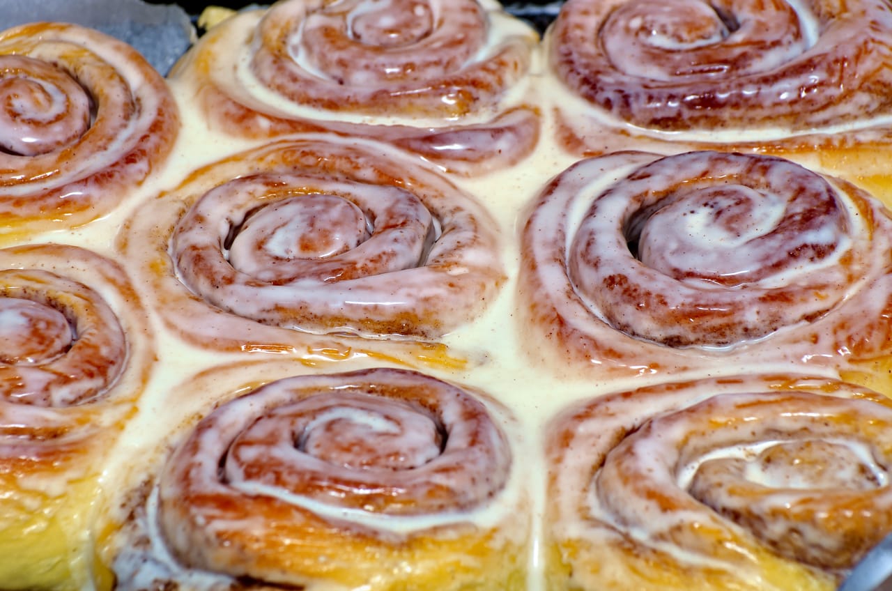A pan of cinnamon rolls covered in white icing