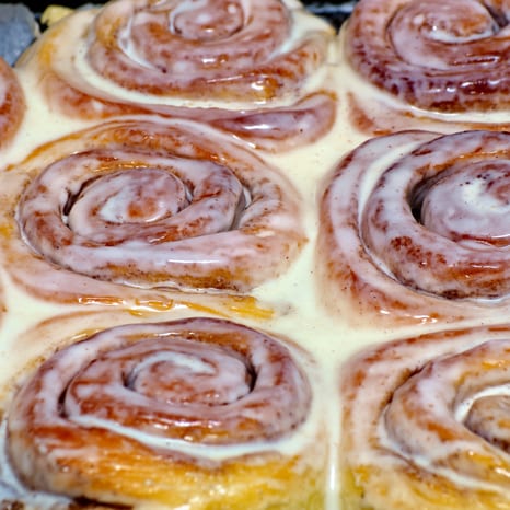 A pan of cinnamon rolls covered in white icing