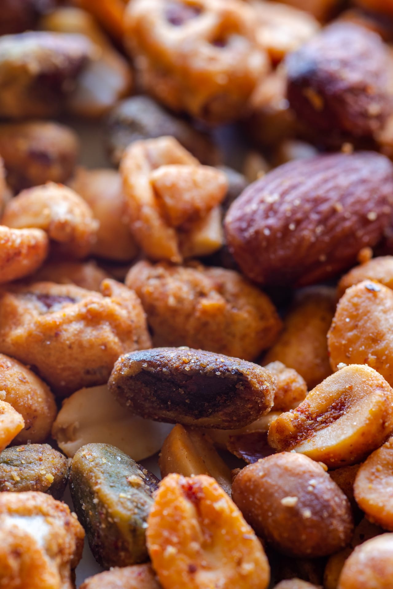 A close-up of spiced roasted mixed nuts including almonds, cashews, and pistachios
